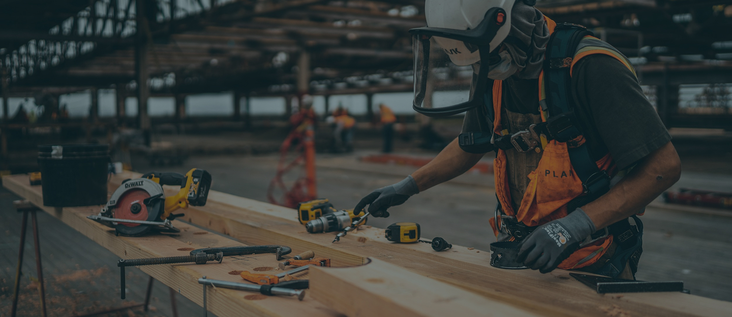 Construction worker using a saw and other tools.